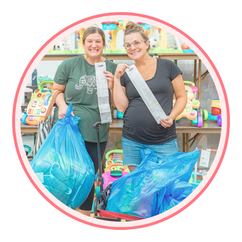 A mom and grandmother stand beside a rack of clothing at a JBF sale in Texas.